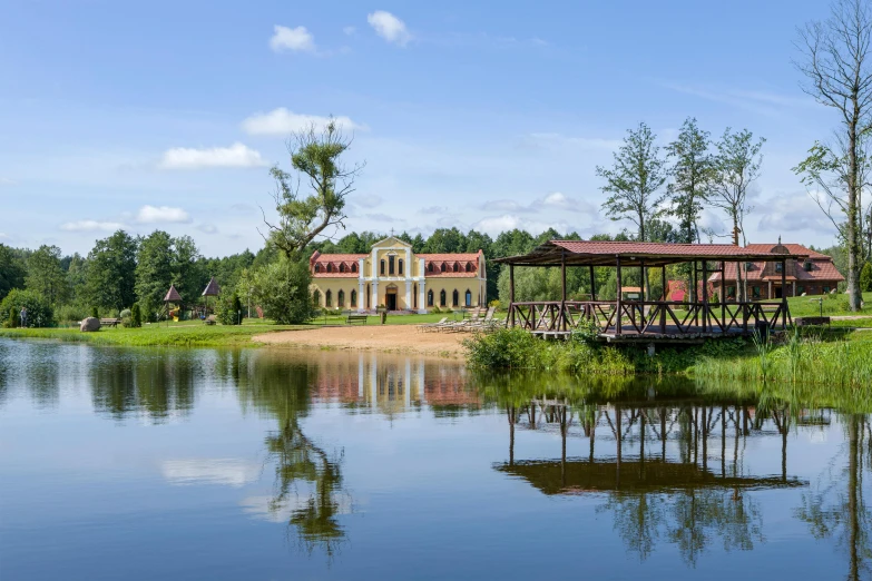 a house sits near the water as it is surrounded by trees