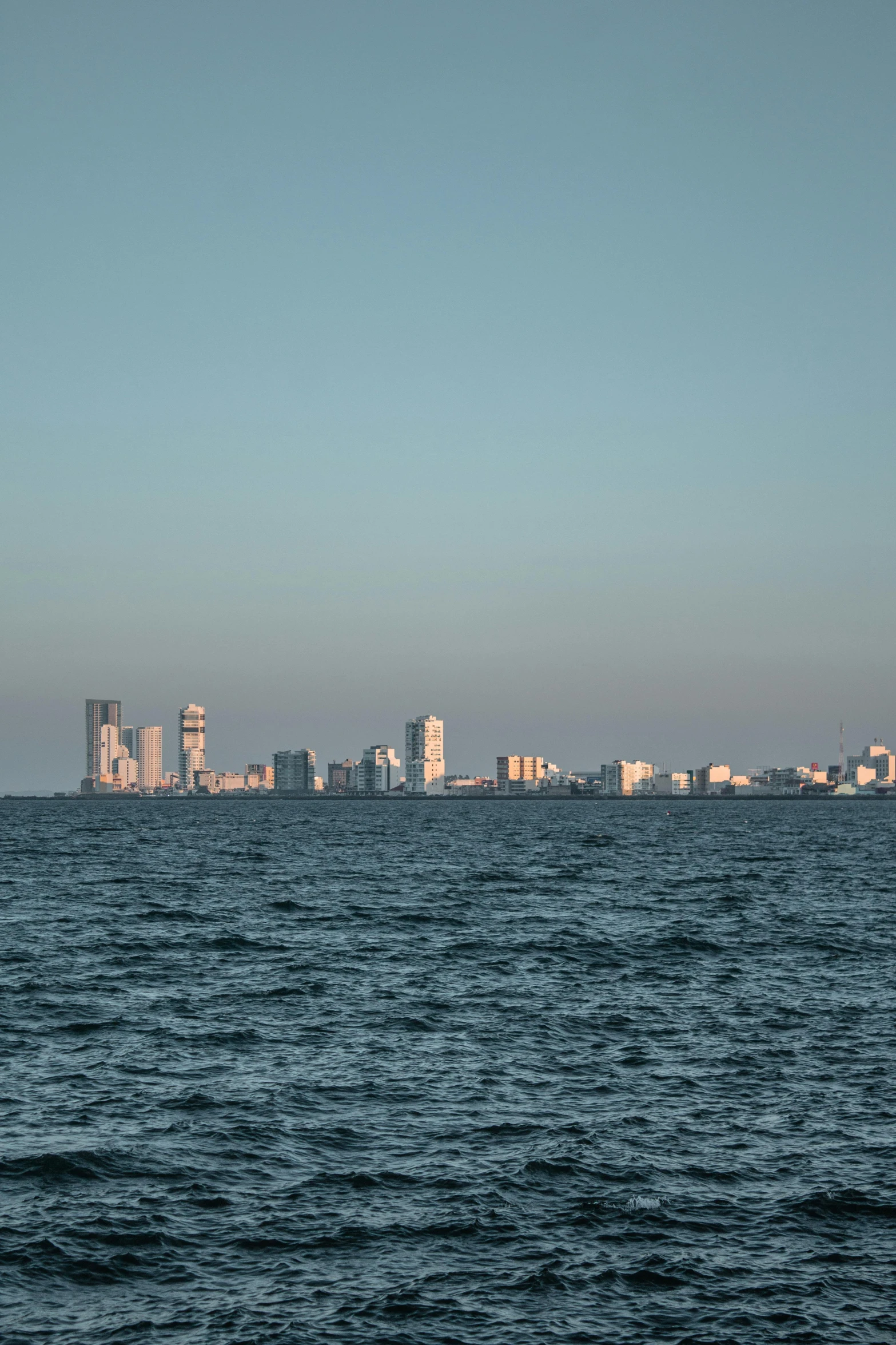 skyline over water with tall buildings in the background