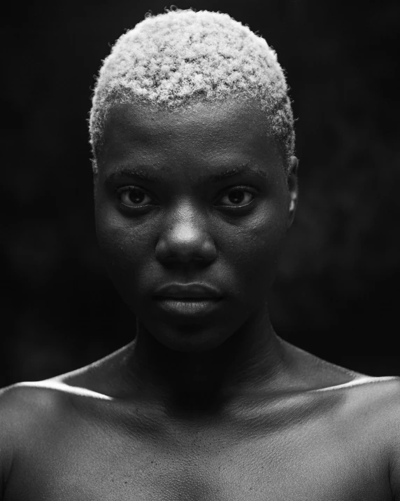 black woman with white hair posing in front of a black background