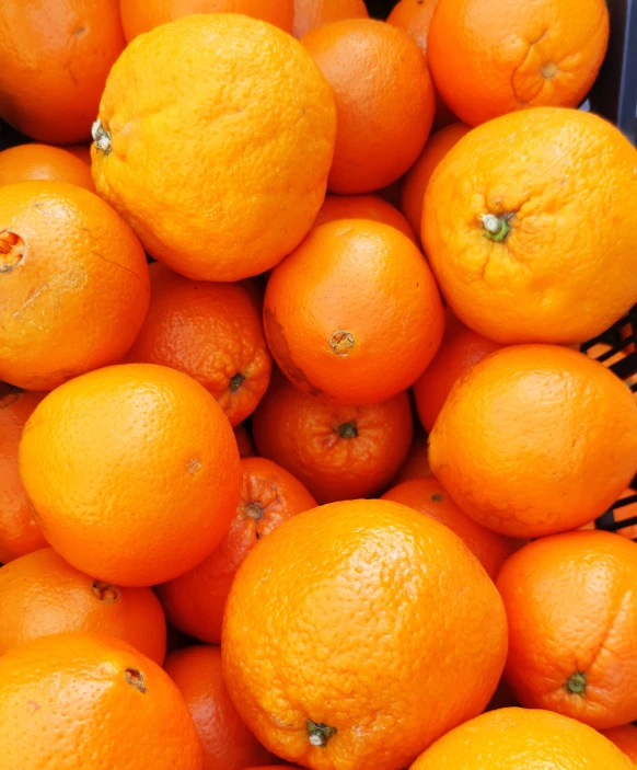 closeup of an abundance of tangerines in a woven bowl