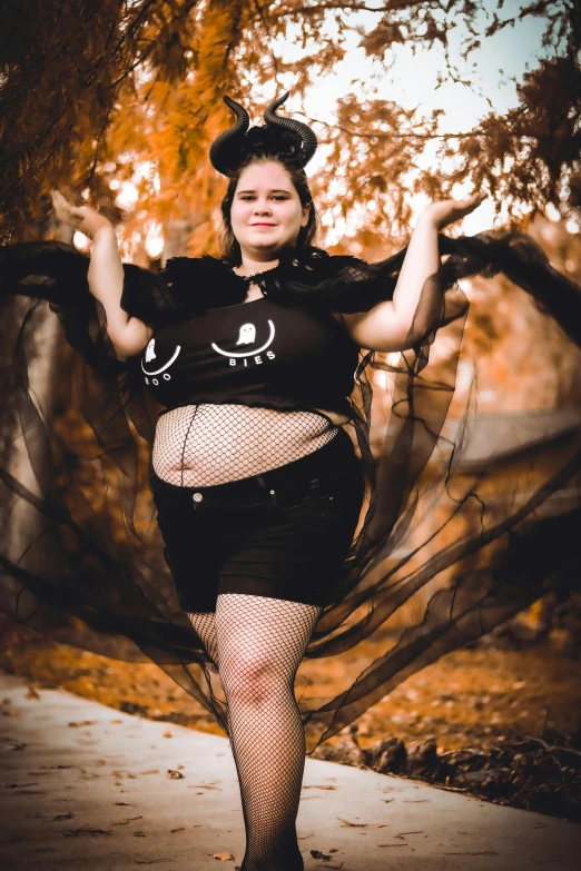 a woman is wearing a black costume and has her hands in the air