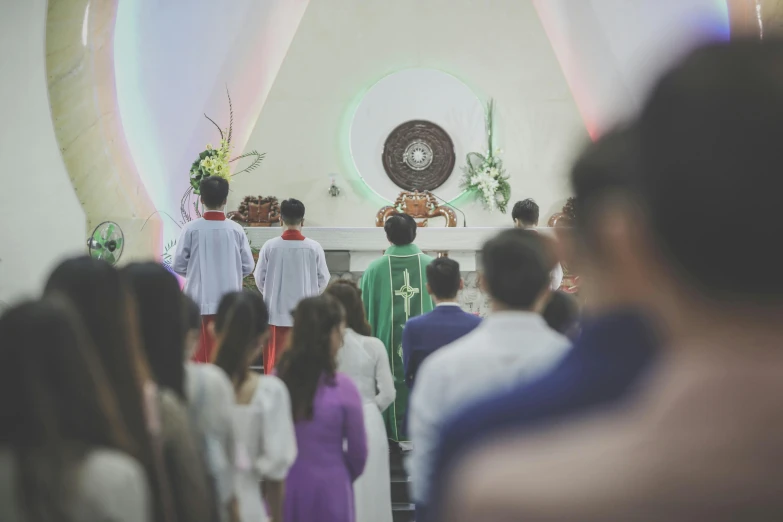 a priest is leading a ceremony for several people