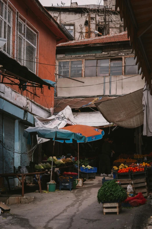 the outdoor produce market has two umbrellas over them