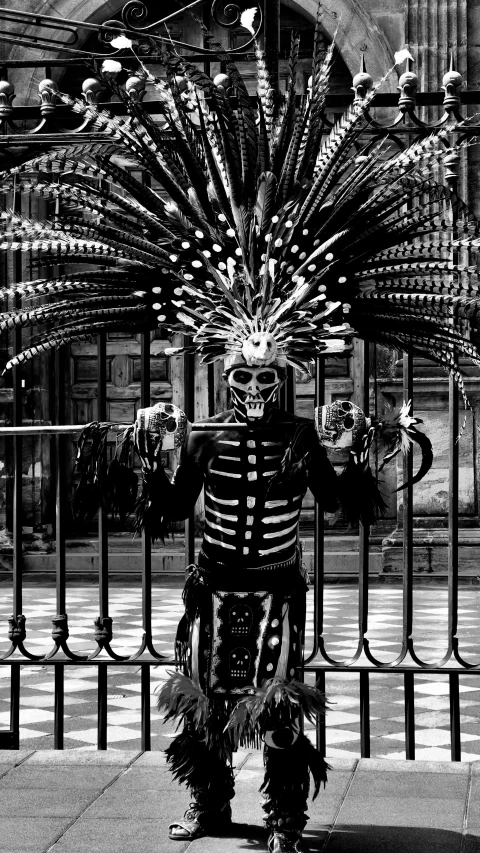 a person in costume standing next to a gate