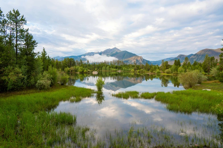 this is a small pond and it looks like the mountains are reflected in the water