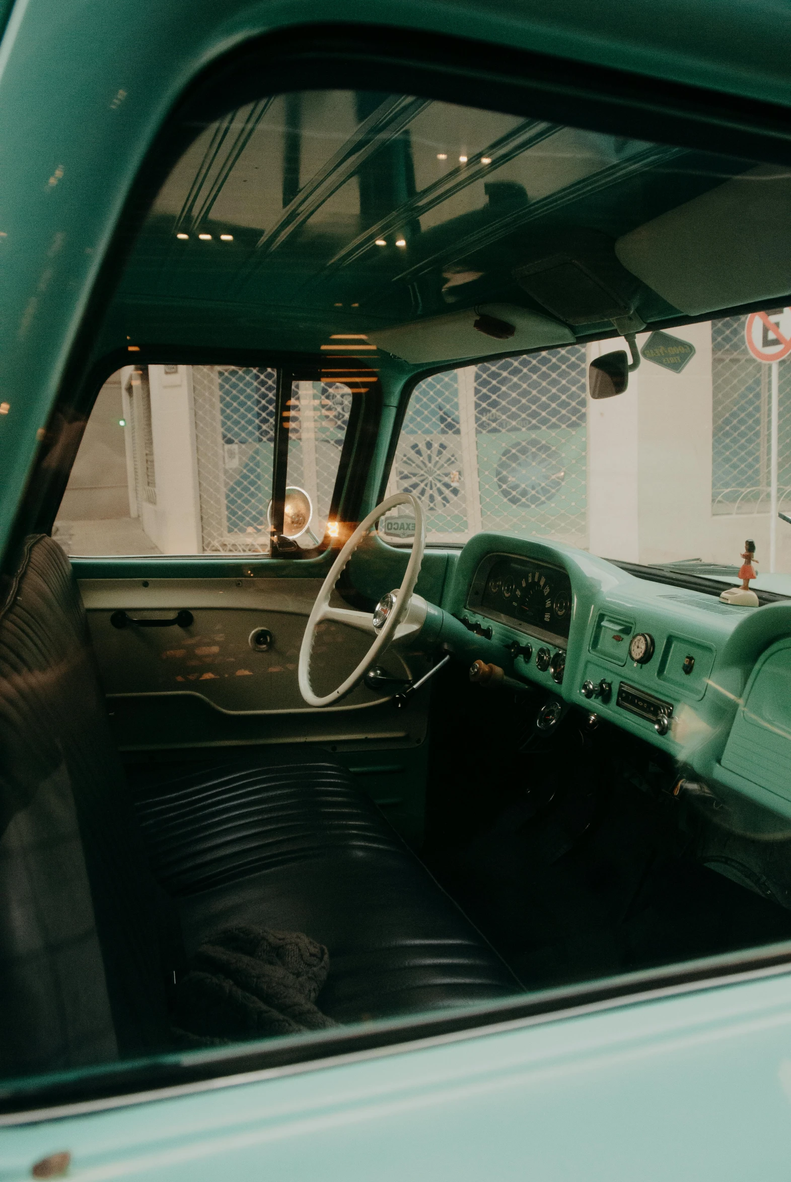 an old green truck parked in a parking lot