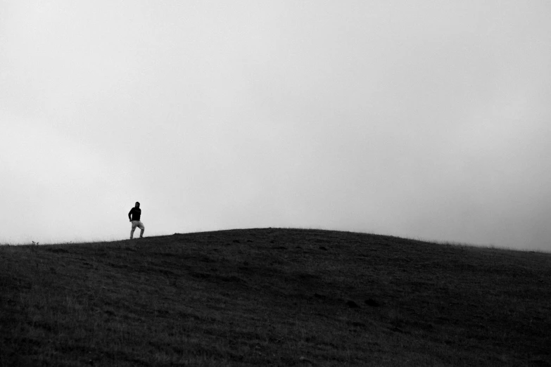 a man is standing on a grassy hill