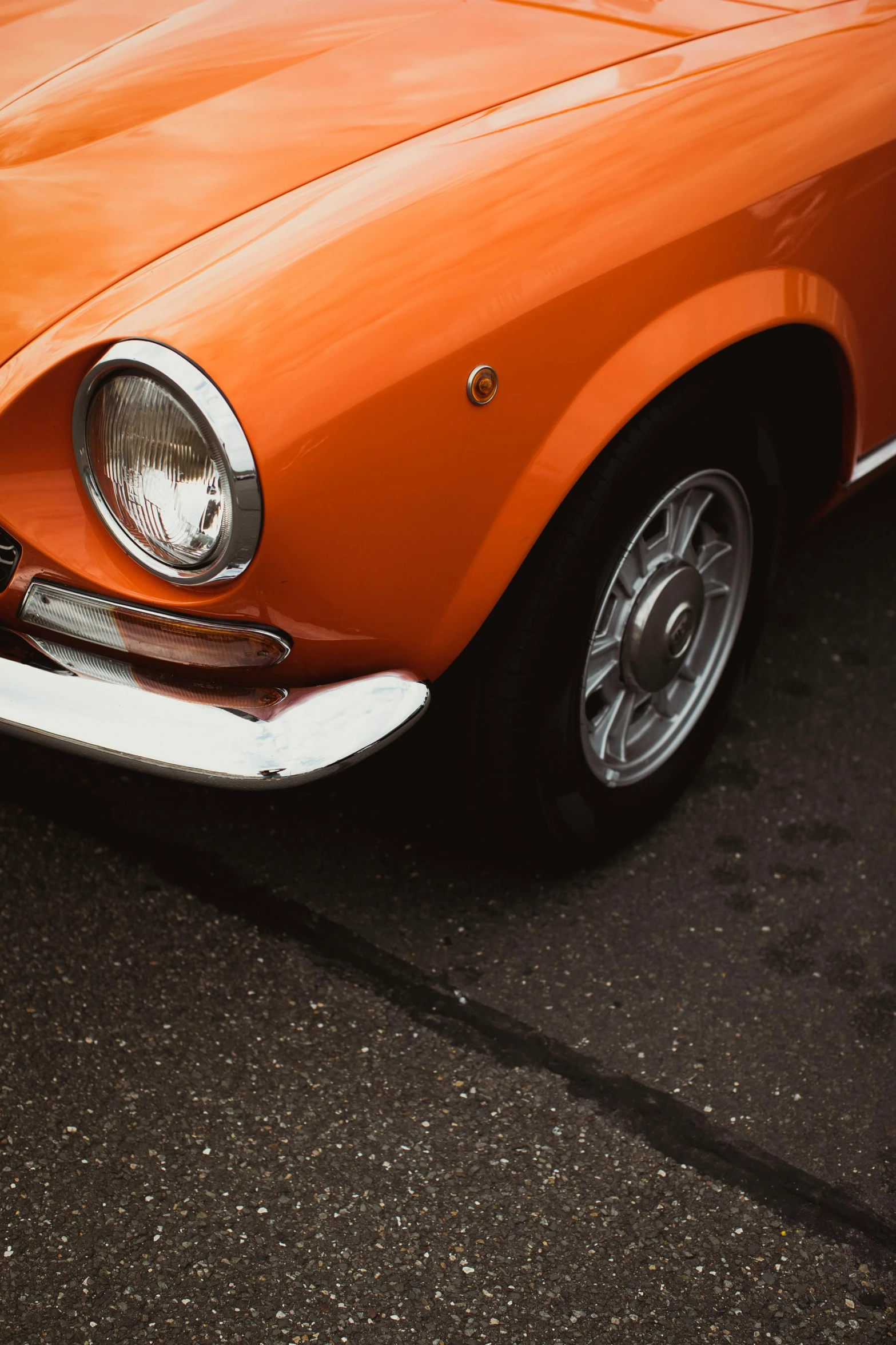 an orange convertible is parked near other vehicles