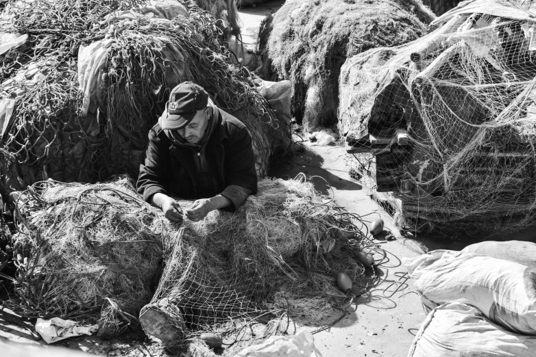 an old po of a man working in a field with lobster nets