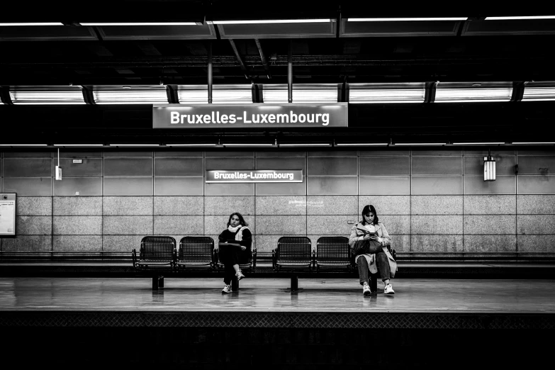 two people sitting on benches at an airport