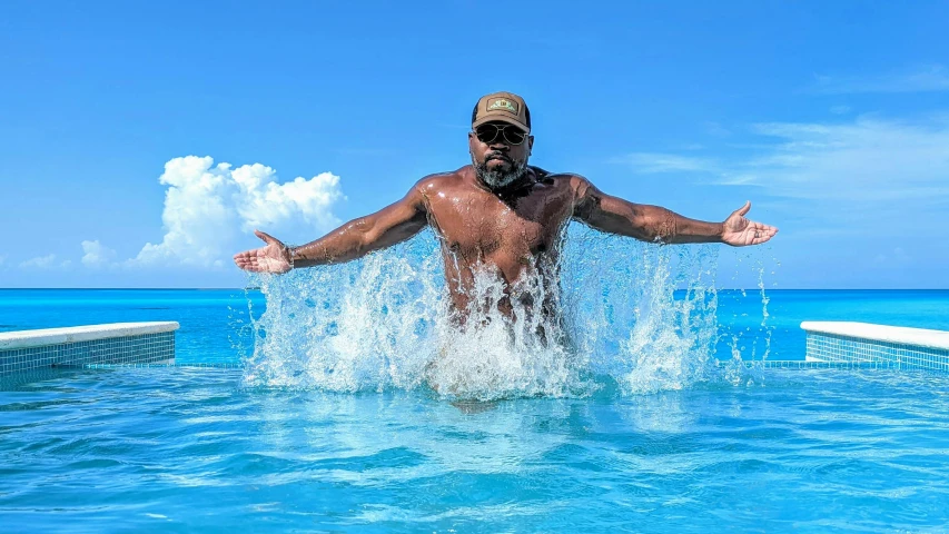 man with hat jumping into water near pool