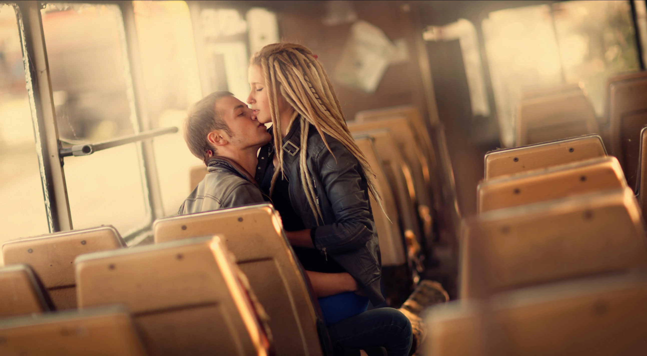 the man and woman are kissing on the bus