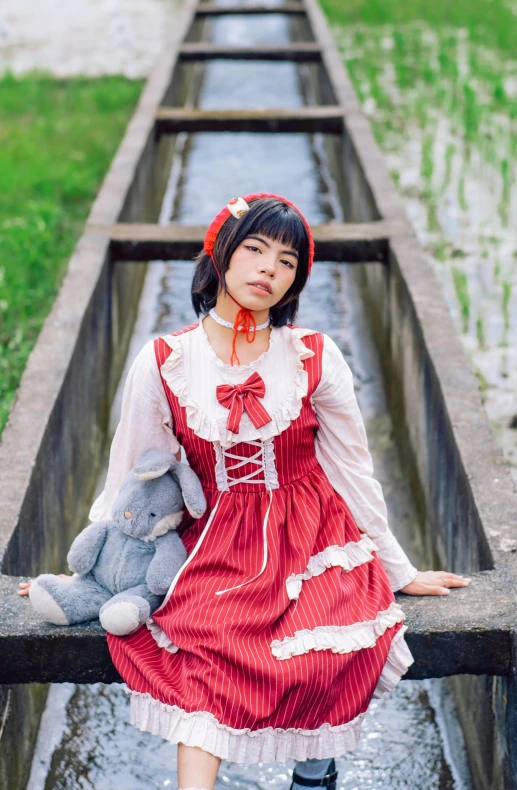 a woman standing near a pipe in a field