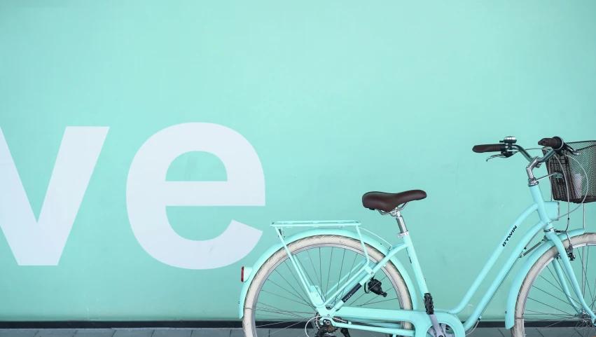 the bicycle is parked on the sidewalk beside the building