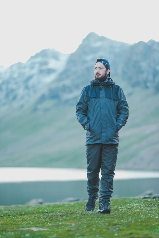 a man is standing on a hill in the mountains