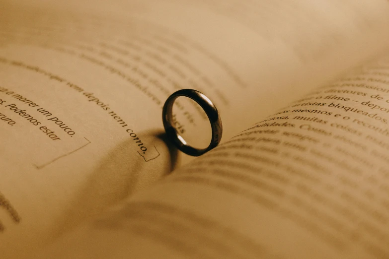 a close up view of a ring resting on an open book