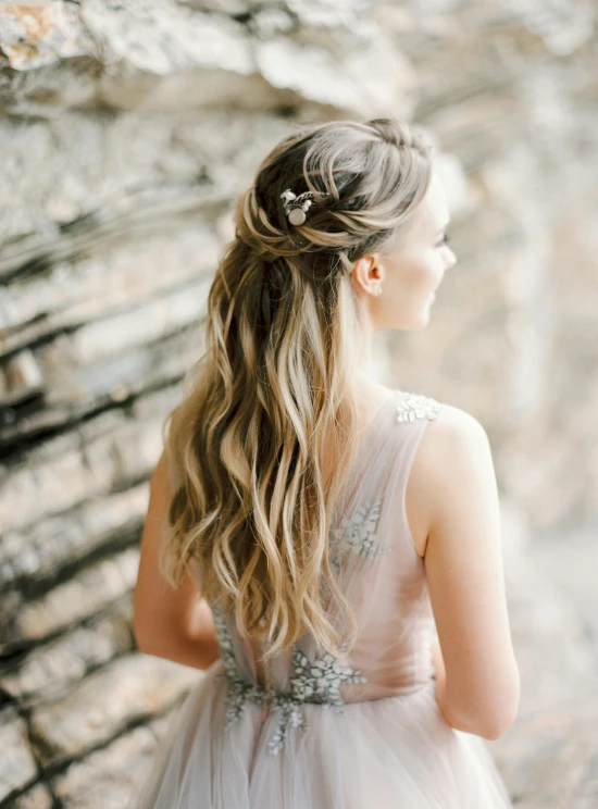 a woman in a wedding dress is seen from the back