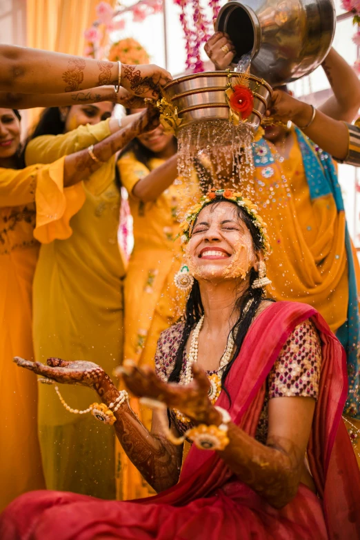 smiling woman getting a face wash at hindu wedding