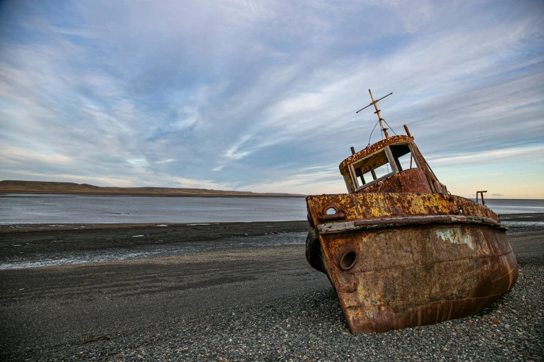 a ship sitting in the sand at the beach