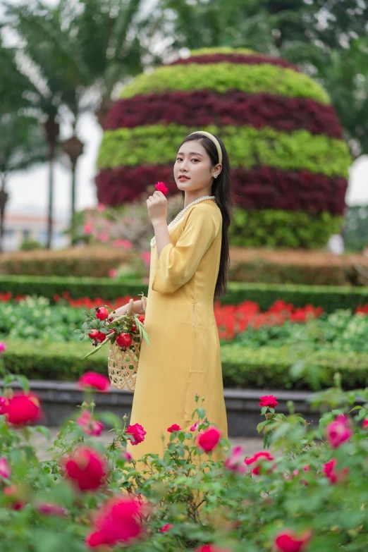 a woman standing in a garden holding flowers