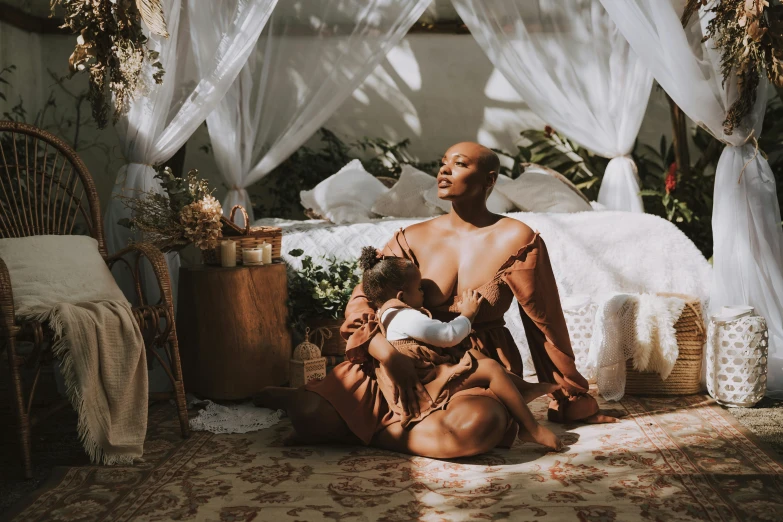 a woman holds a child in her arms in the middle of a room with sheer ds and bed and table