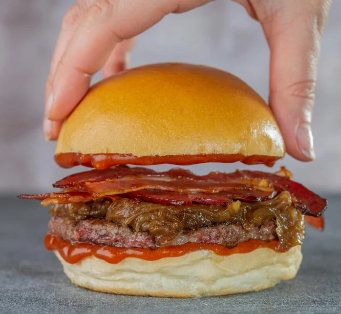 an image of someone holding a hamburger in their hand