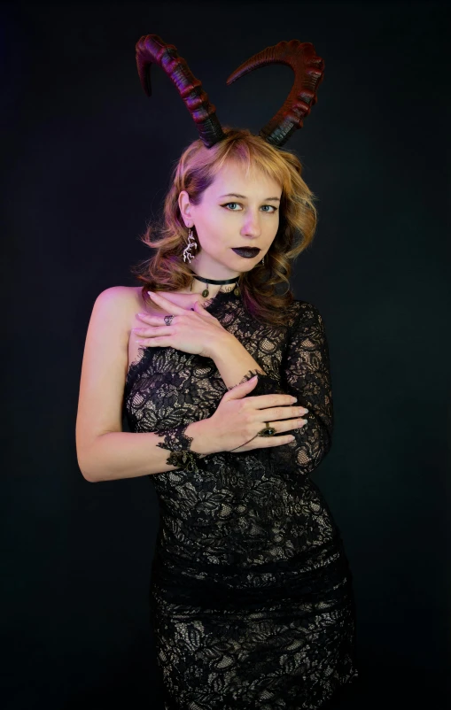 a woman with horns, black dress, and earrings