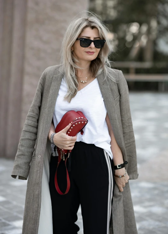 a blonde woman with sunglasses, sweater and jacket