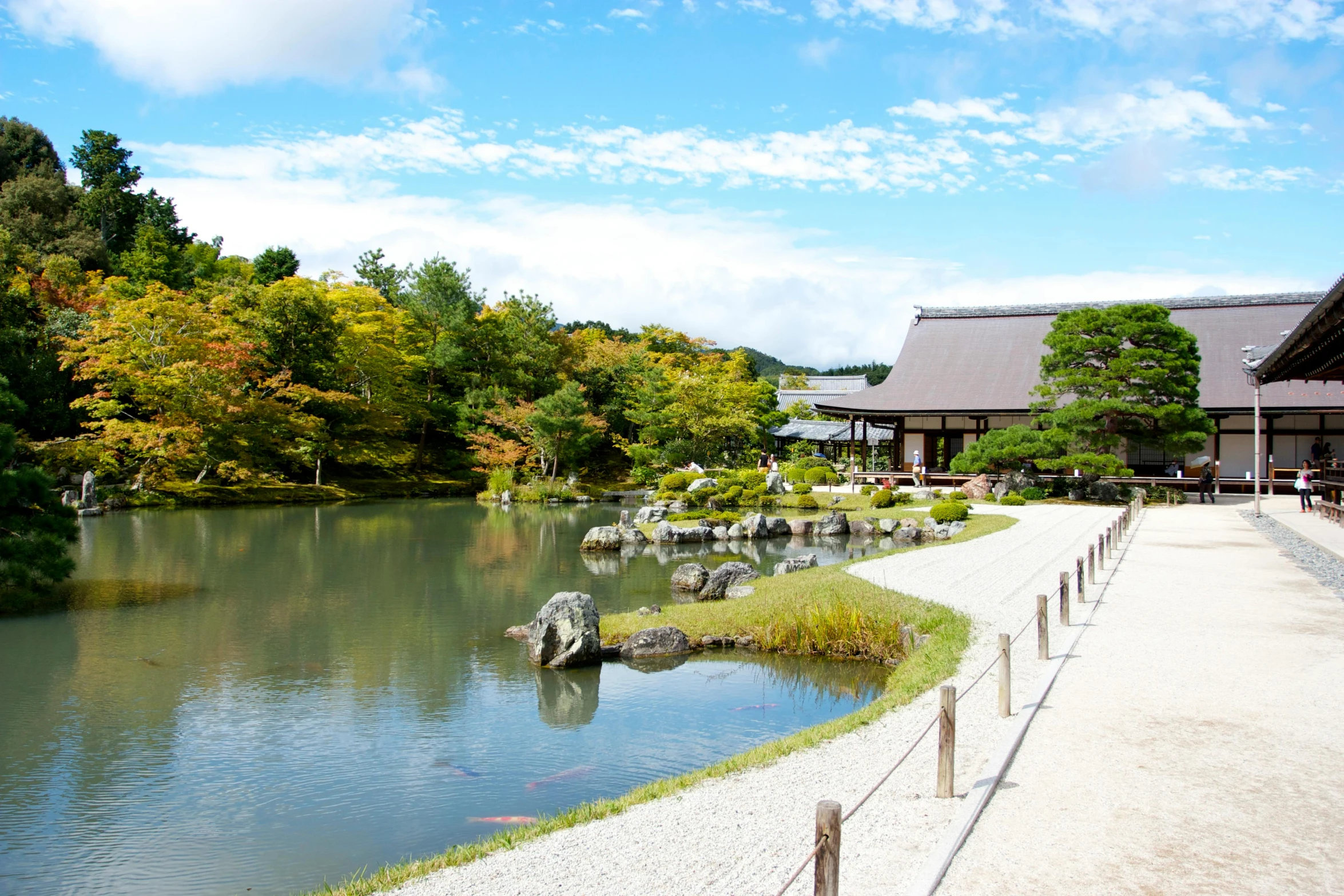 a large lake in front of a house near trees