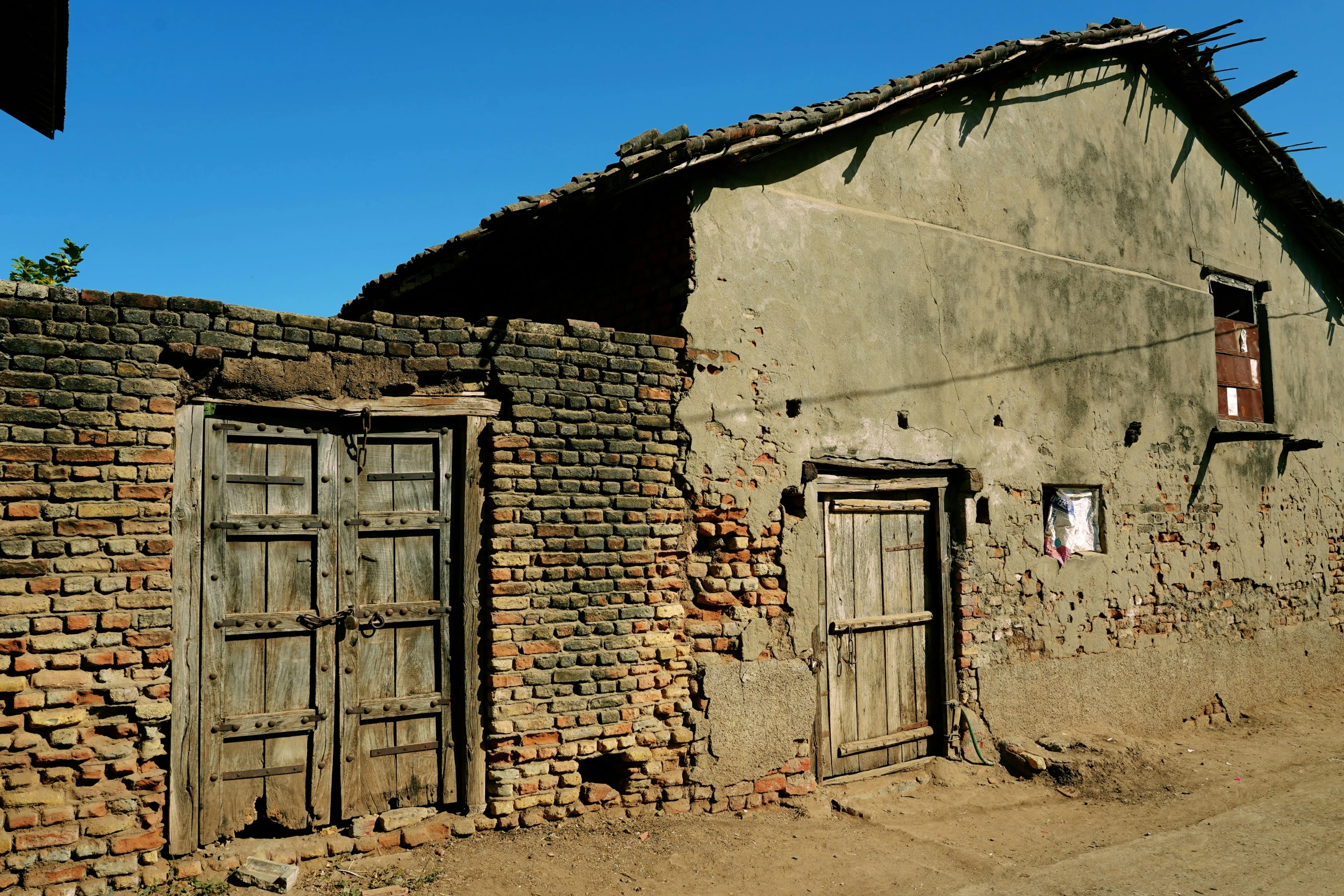 an old shack is sitting beside a little road