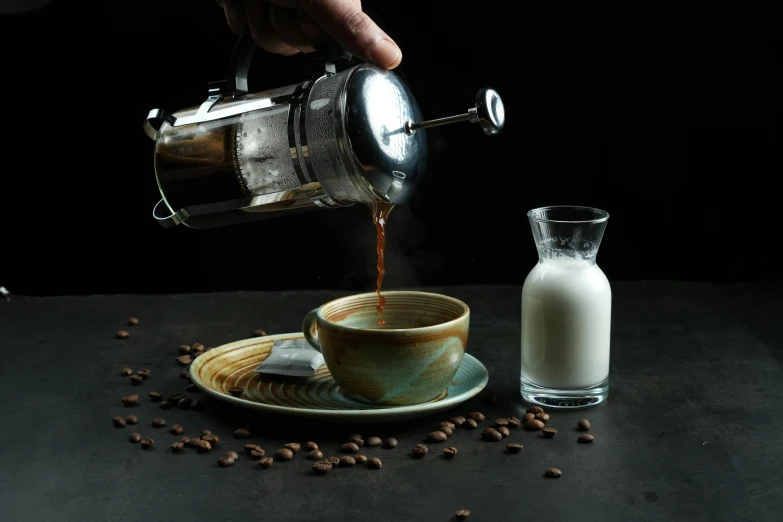 a man pouring milk into his coffee cup