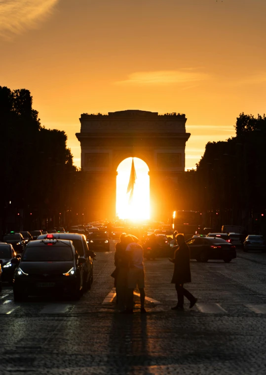 silhouettes of traffic in front of the arch of triumph