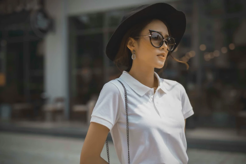 a woman in a hat, sunglasses, and a dress shirt