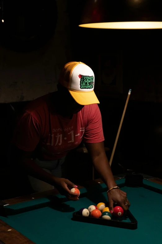 a man putting pool balls on a pool table