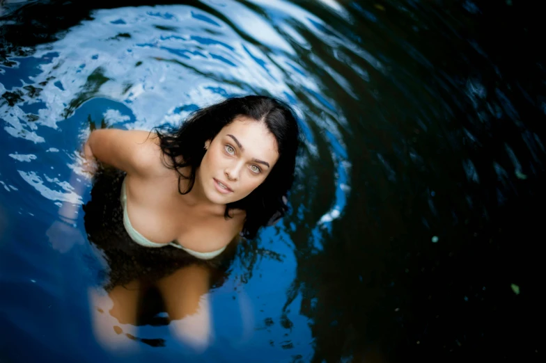 a girl in a pool, with her head peeking from the water