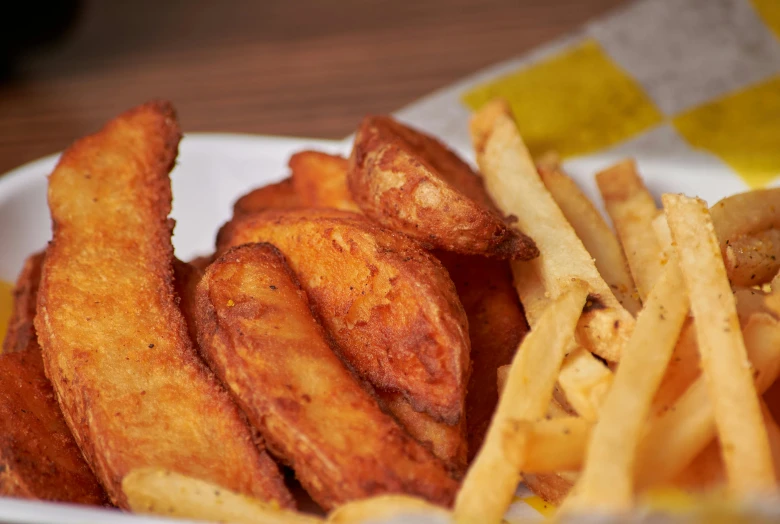 a plate filled with fried chicken sticks and some fries