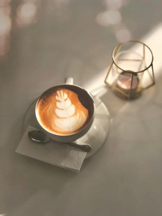 a cappuccino with a heart design on the foam sits in a bowl