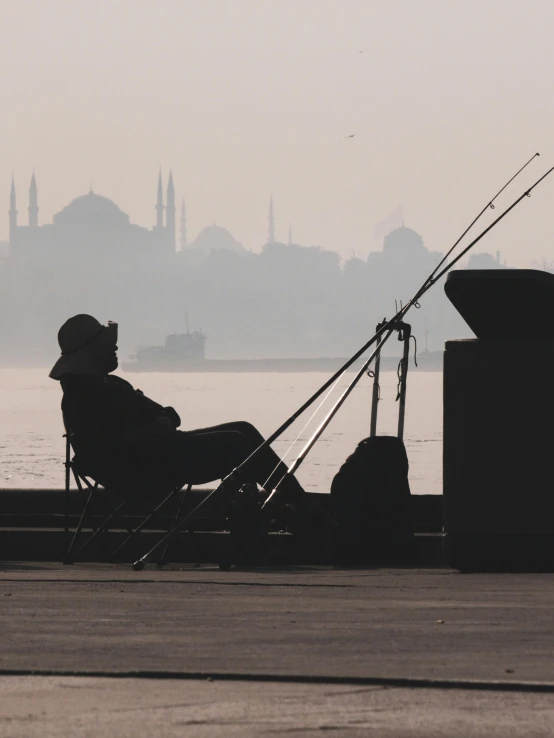 a fisherman sits on the deck while fishing