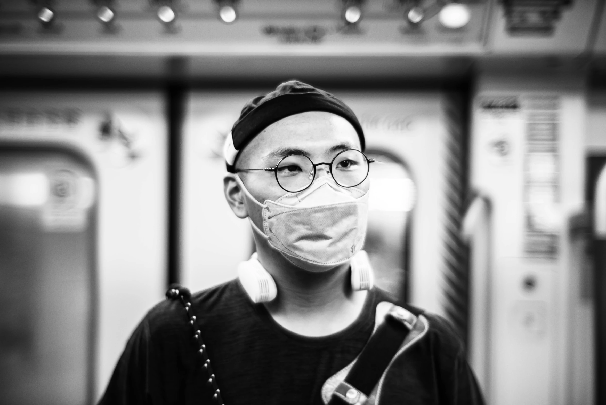 a man with glasses and a mask on in a train