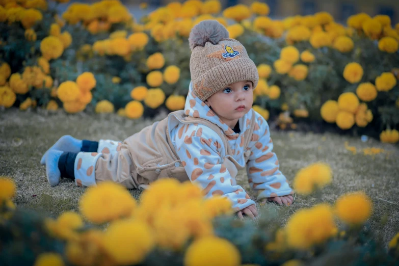 a small child laying in the grass among yellow flowers