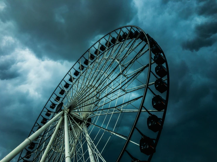 an image of a ferris wheel under stormy skies