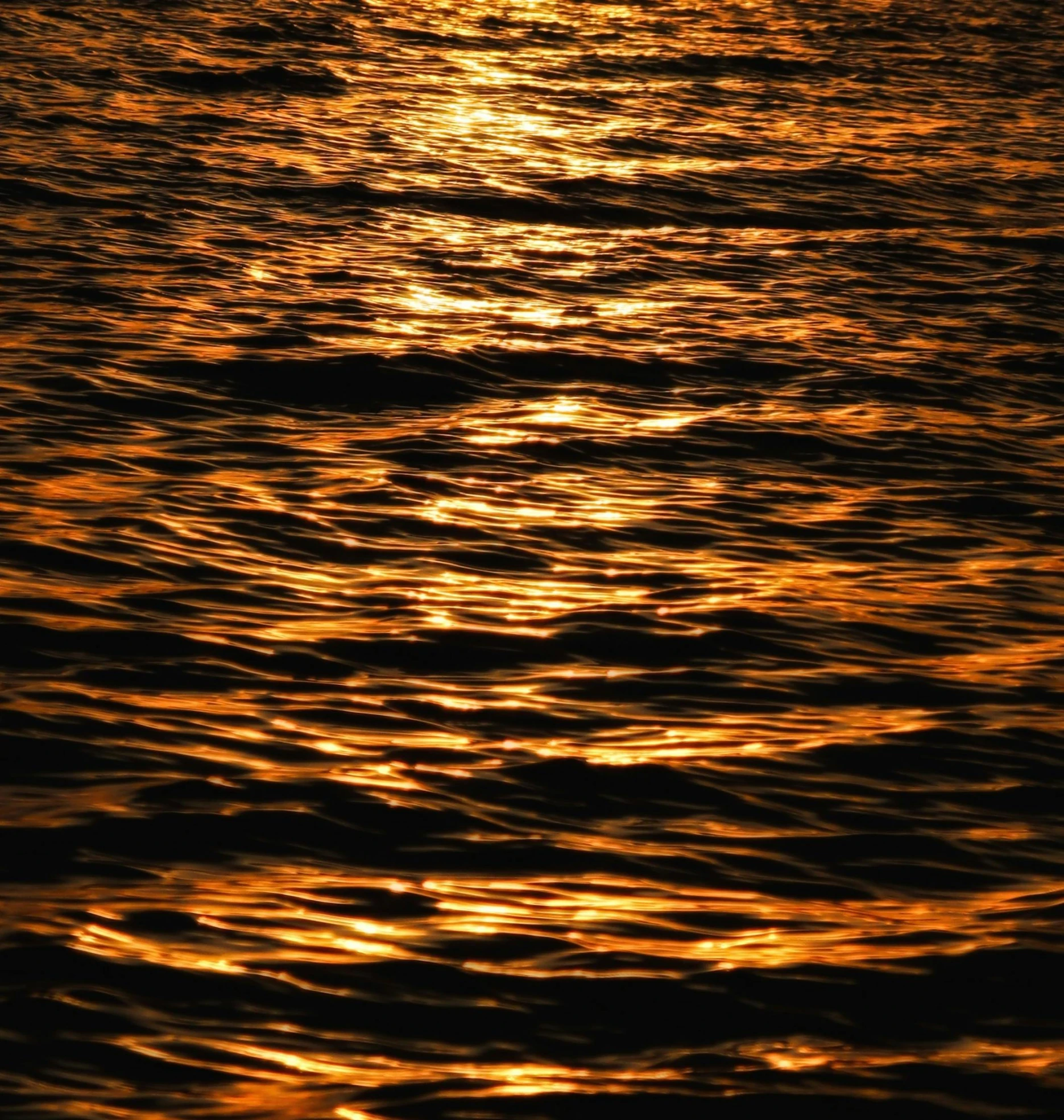 some clouds are reflected in the water as the sun sets
