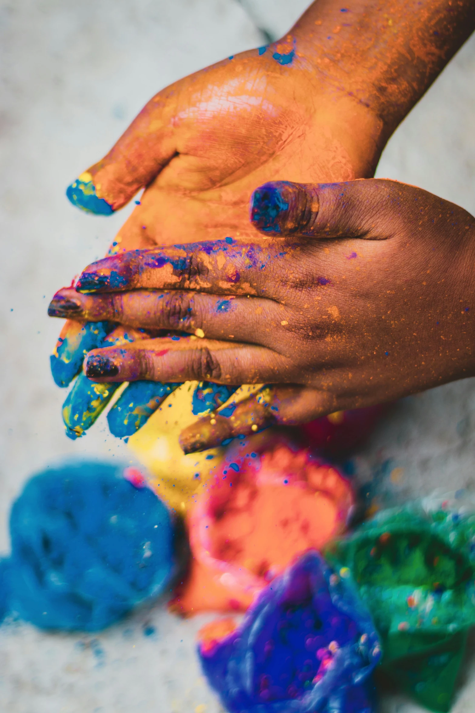 an adult holding a blue yellow and red paint