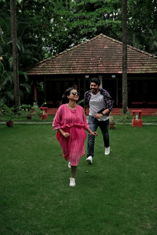 a man holding a bat walking past a lady in a pink dress