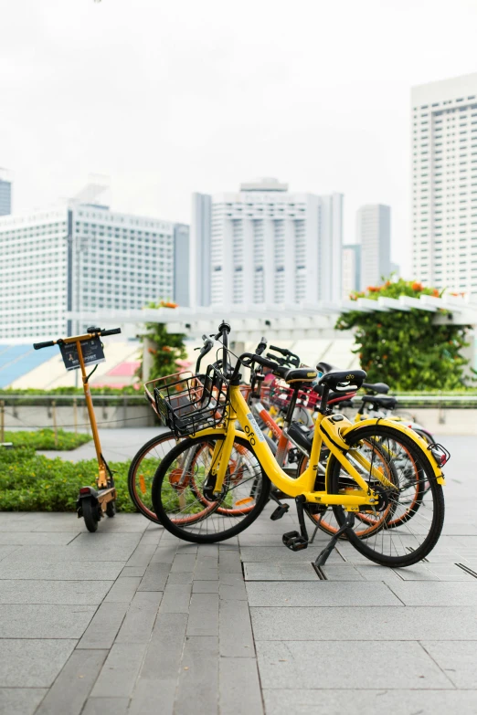 several bikes and scooters are parked next to a pole