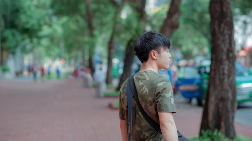 a young man with a backpack walks down a brick path