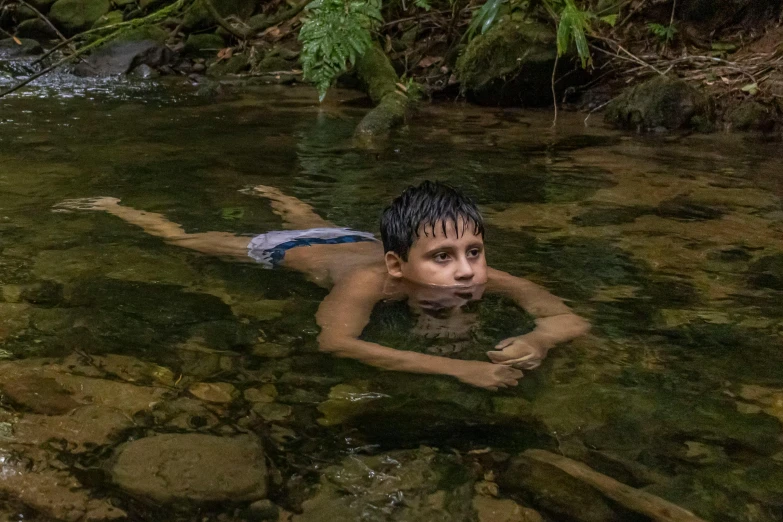 the boy is floating in the river and having fun