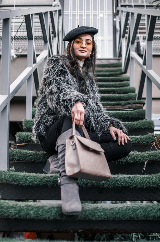 a woman sitting on the stairs with her purse