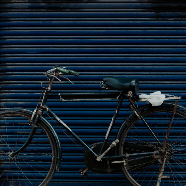 an old bicycle parked against a metal garage door