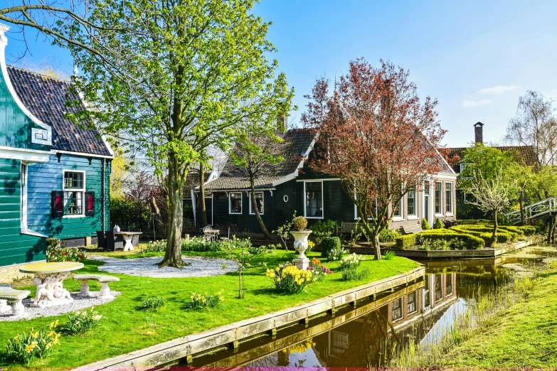 two small green buildings on the edge of a waterway